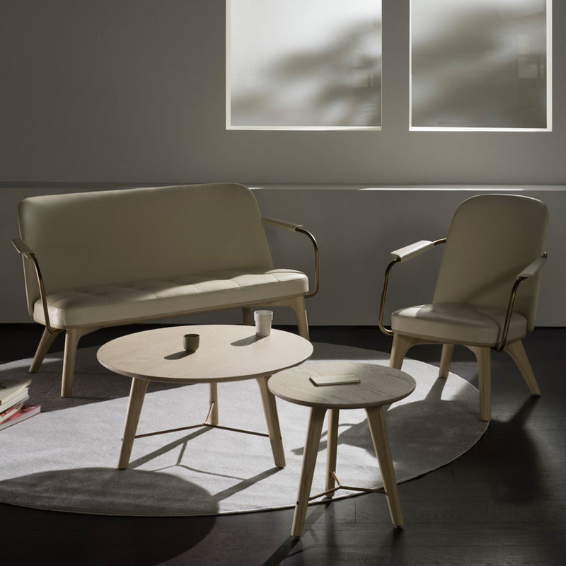 Neutral beige sofa and chairs with light wood accents, complemented by round tables on a circular gray rug.