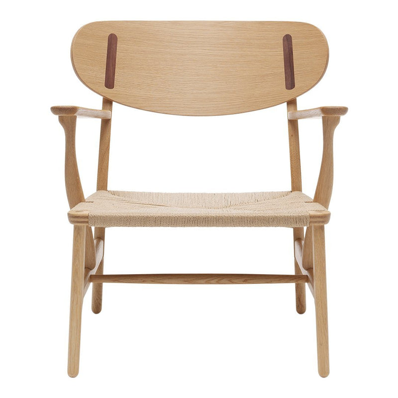 Wooden chair with a light oak finish, featuring a smooth grain and contrasting dark leather accents on the backrest.