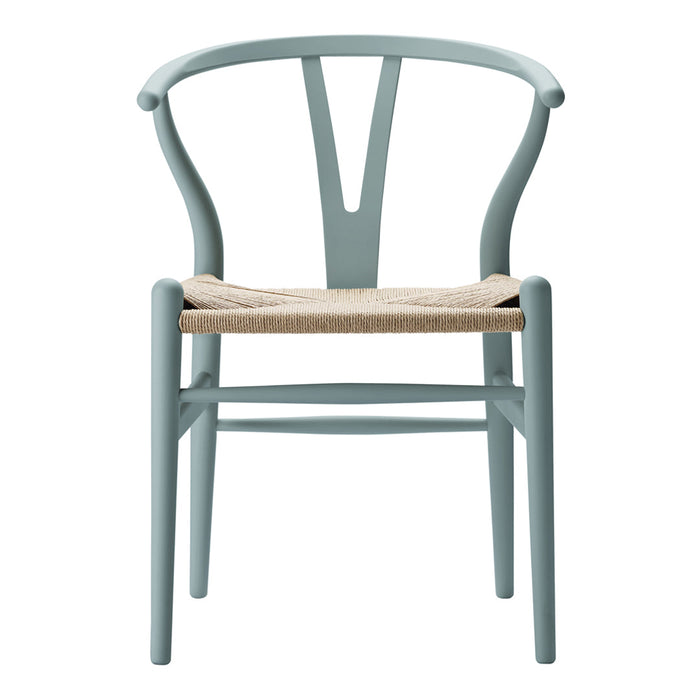 Light blue wooden chair with a woven natural fiber seat and sleek, minimalistic design.