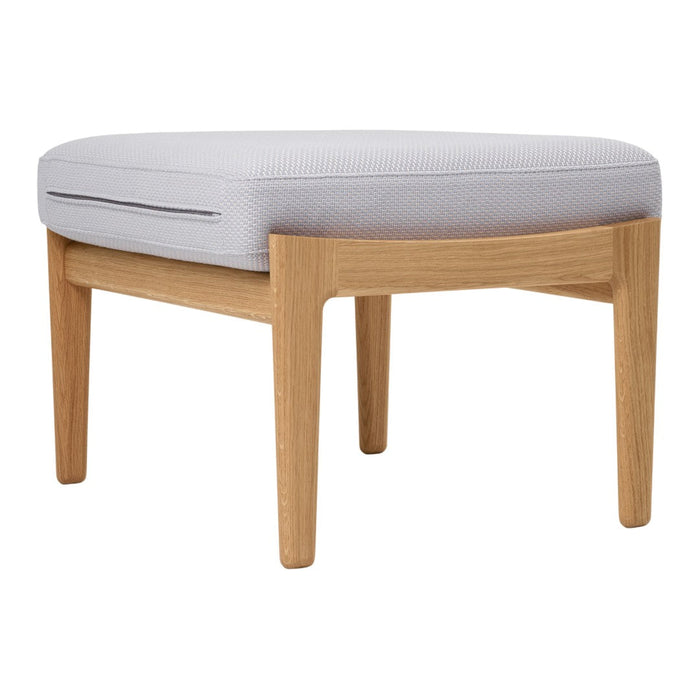 Light gray upholstered ottoman with a smooth, rounded design and natural wooden legs. Modern and minimalist style.