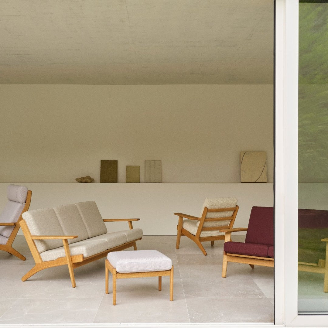 "Modern seating in beige, maroon, and white upholstery with light wood accents against a minimalist backdrop."