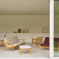 "Modern seating in beige, maroon, and white upholstery with light wood accents against a minimalist backdrop."
