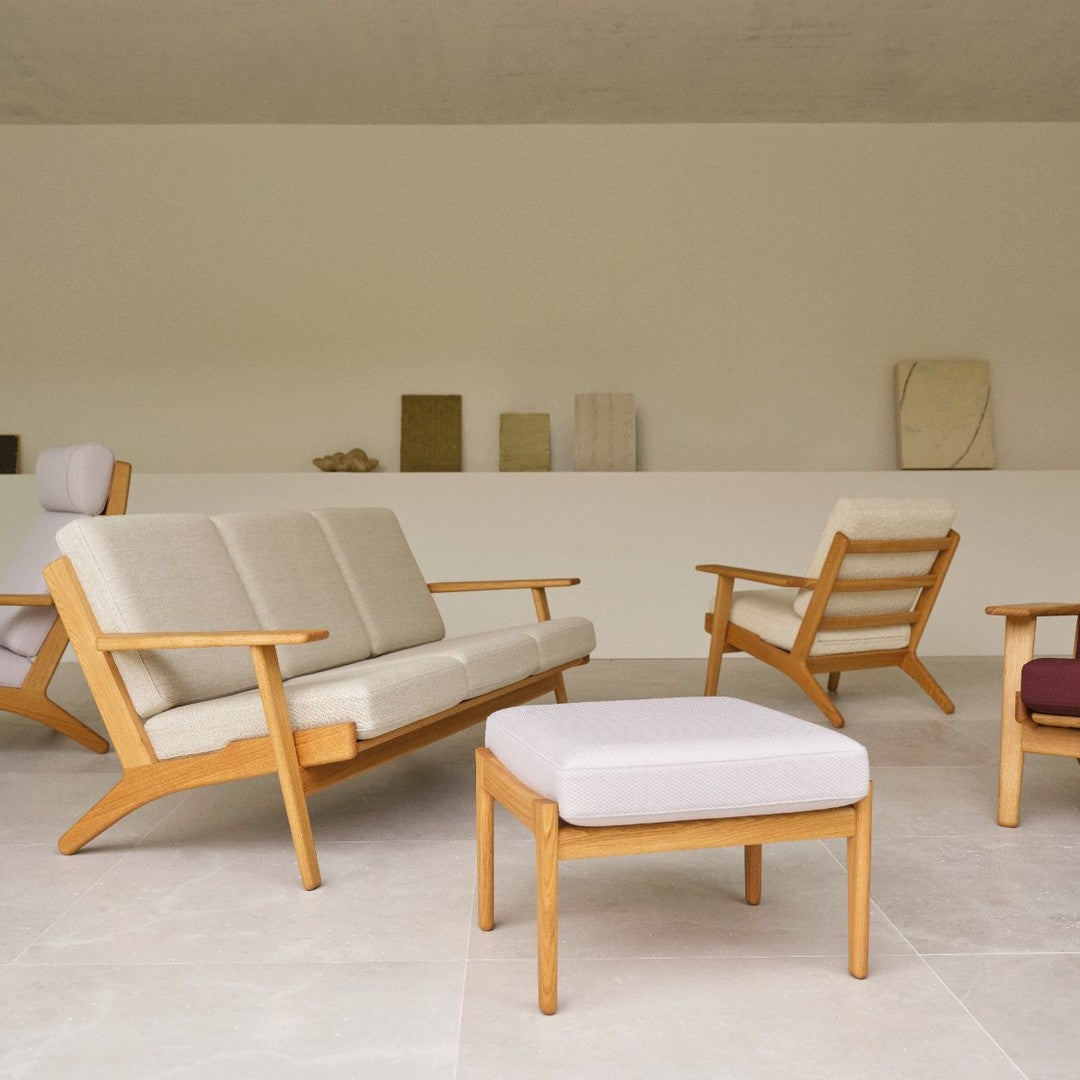 Beige and cream upholstered furniture with light wood accents, featuring a minimalist design and subtle geometric patterns.