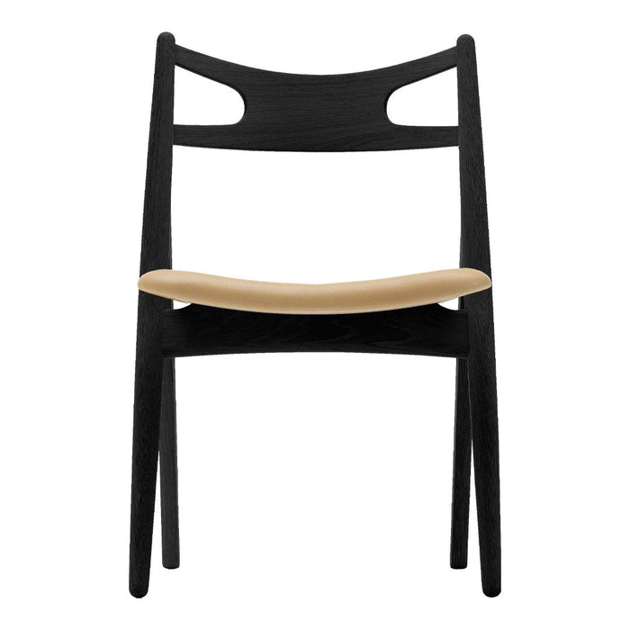 Black wooden chair with a smooth light beige seat and minimalist design, featuring two rear cutout patterns.