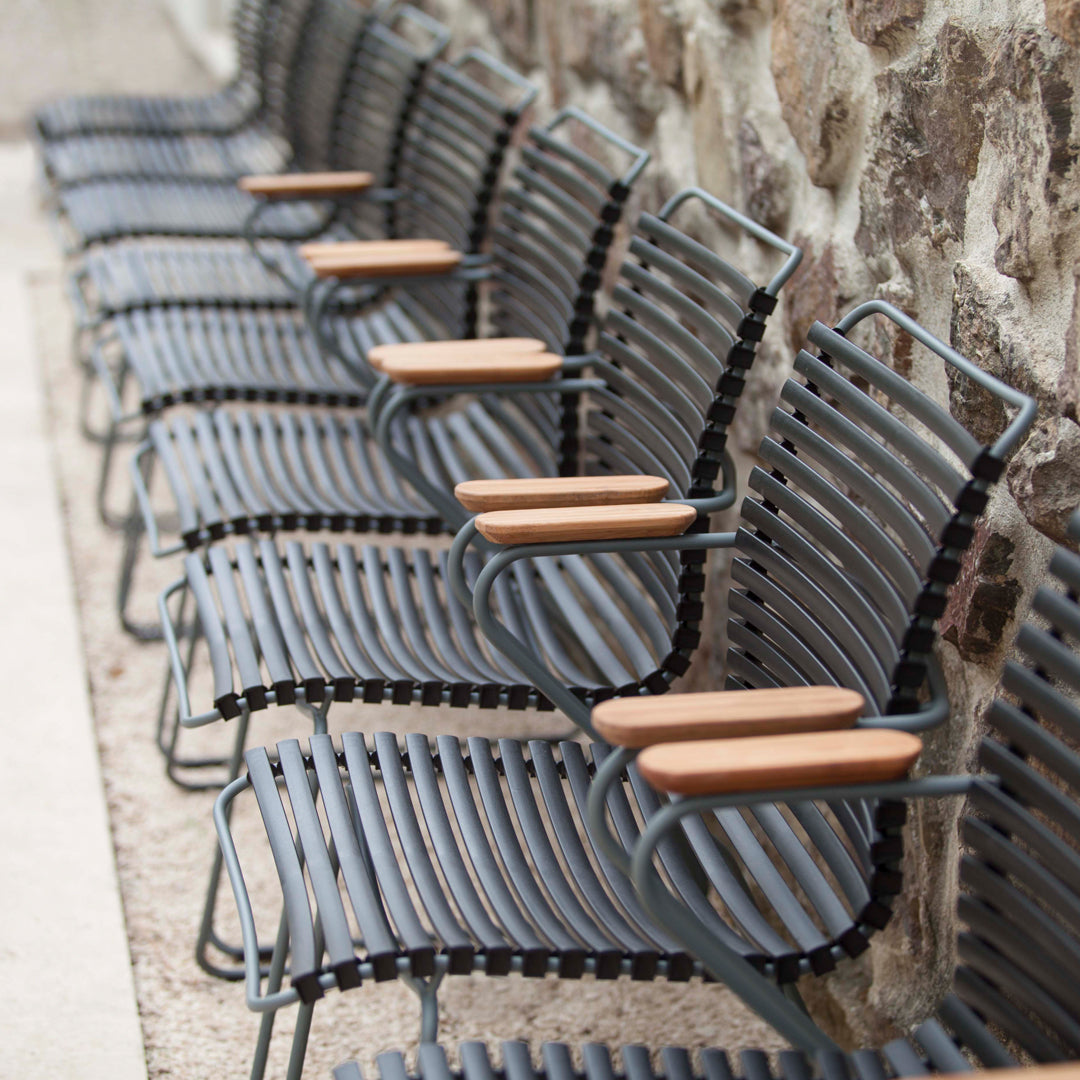 "Row of gray metal chairs with wooden armrests, featuring a modern striped pattern."