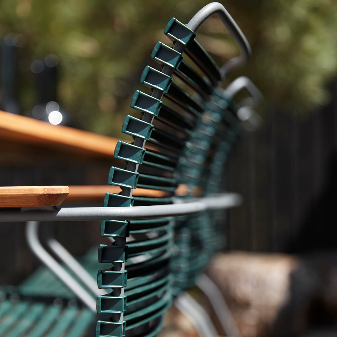 Stylish green metal chairs with sleek lines, complemented by a warm wooden table. Perfect for outdoor gatherings.