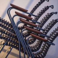 Stacked chairs featuring sleek black metal frames and warm wooden accents, showcasing modern geometric patterns.