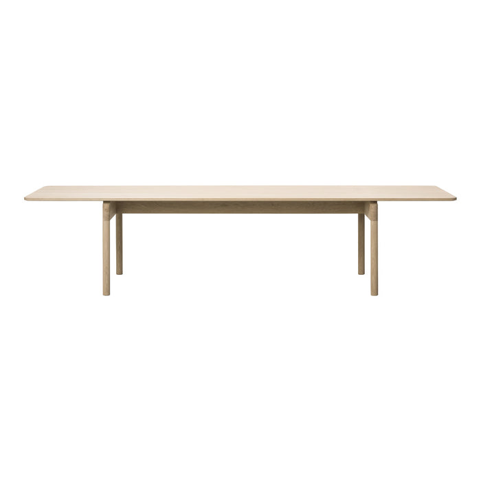 Light beige wooden dining table with a smooth, minimalist design, featuring clean lines and no visible patterns.