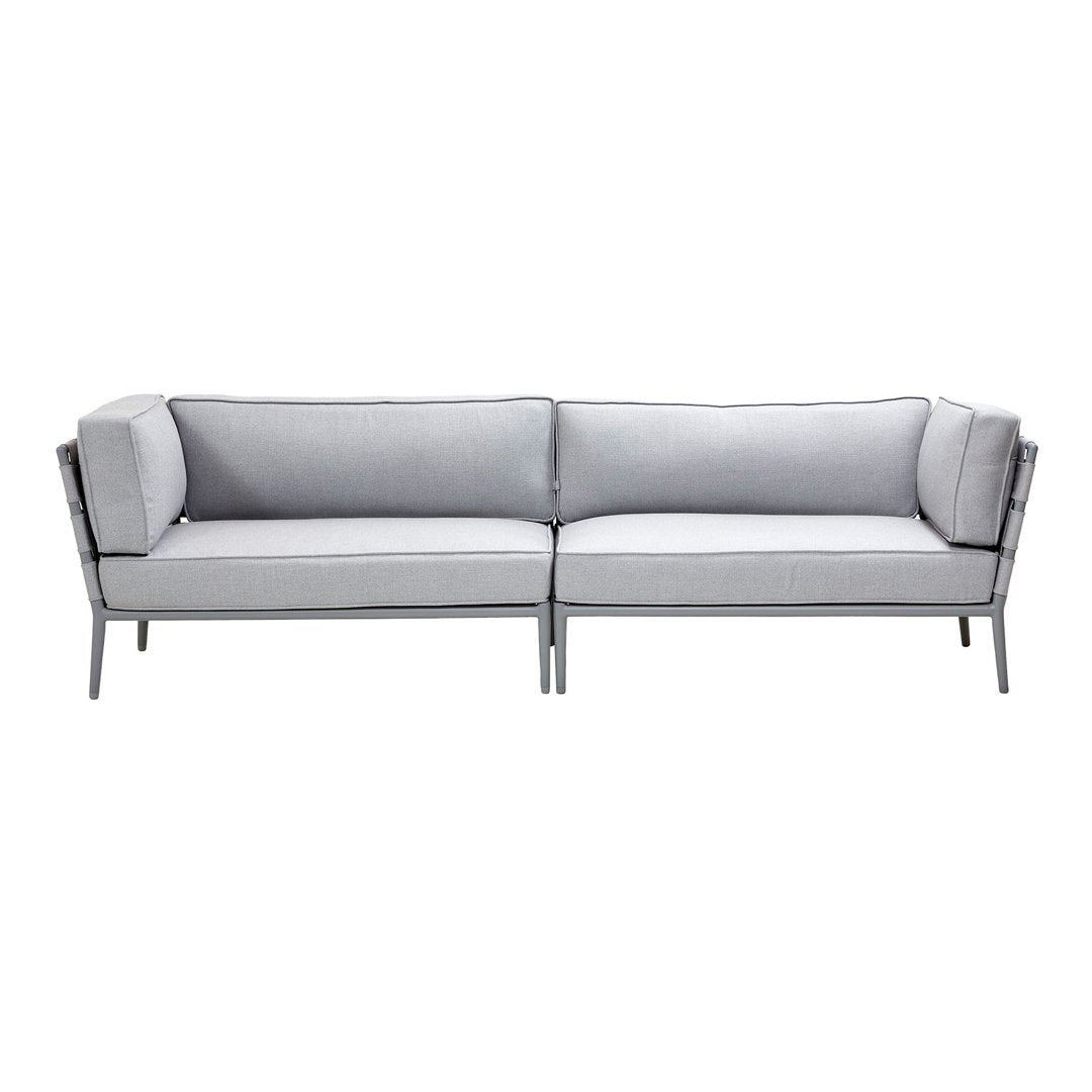 Gray sofa with a sleek modern design, featuring solid gray cushions and contrasting black trim. Perfect for contemporary decor.
