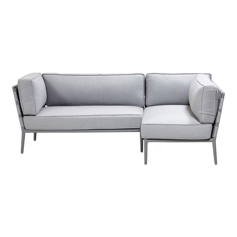 Gray sectional sofa with simple, modern lines and contrasting dark framing. Cozy cushions for a sleek design.