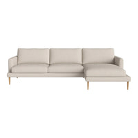 Light beige sectional sofa with smooth fabric, featuring a modern design and tapered wooden legs.