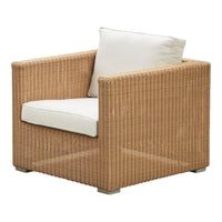 Tan woven armchair with cream accent cushion, featuring a sleek, minimalist design. Perfect for modern interiors.