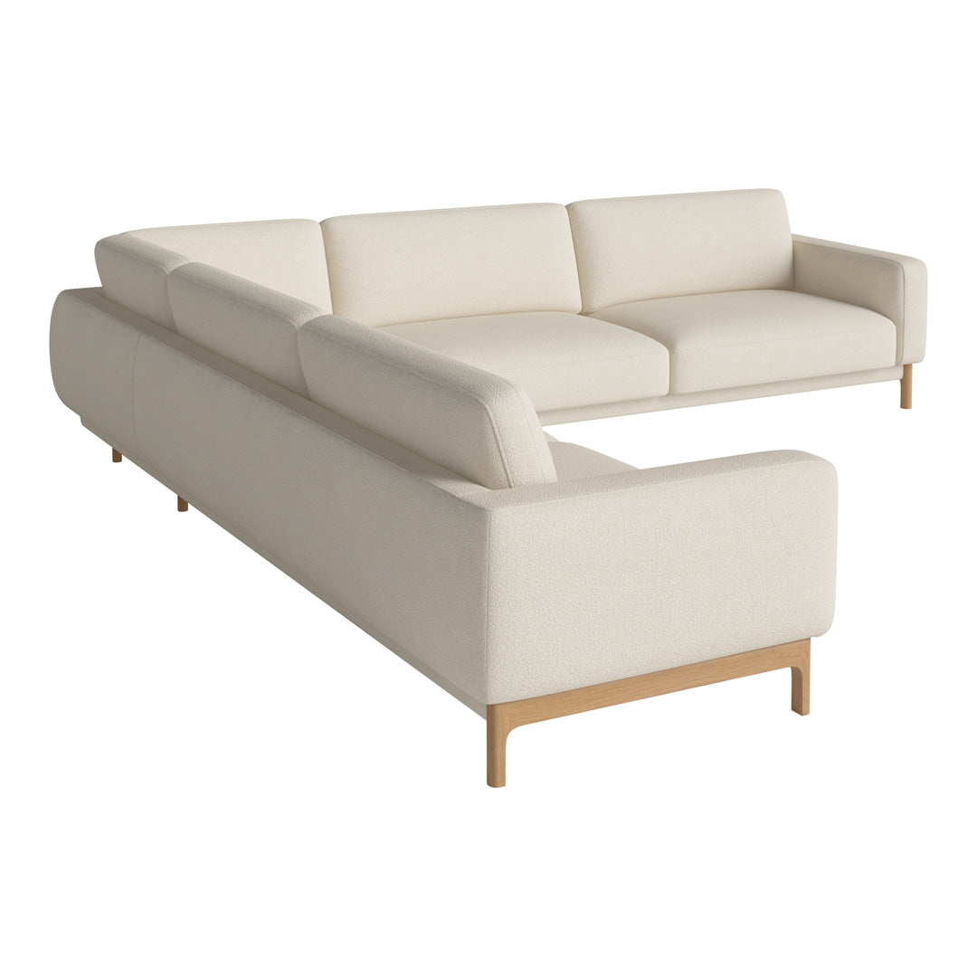 L-shaped sofa in soft beige fabric with clean lines and light wooden legs for a modern, minimalist look.