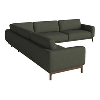 Modern L-shaped sofa in deep green fabric with a minimalist design and wooden legs. Perfect for contemporary interiors.