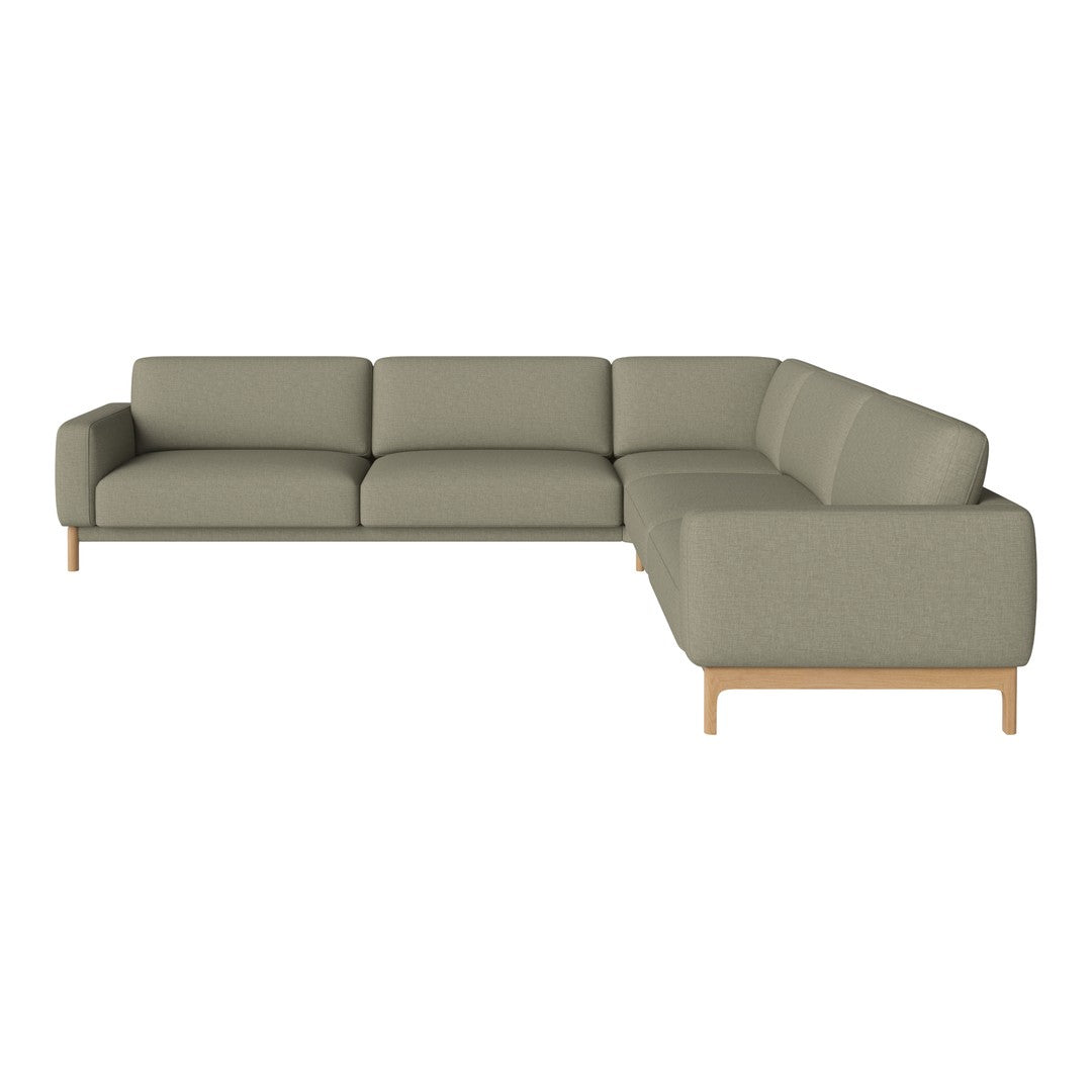 Modern L-shaped sofa in soft olive green fabric with clean lines and light wooden legs. Perfect for contemporary spaces.