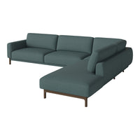 Teal sectional sofa with a smooth fabric texture and minimalist design, featuring clean lines and wooden legs.