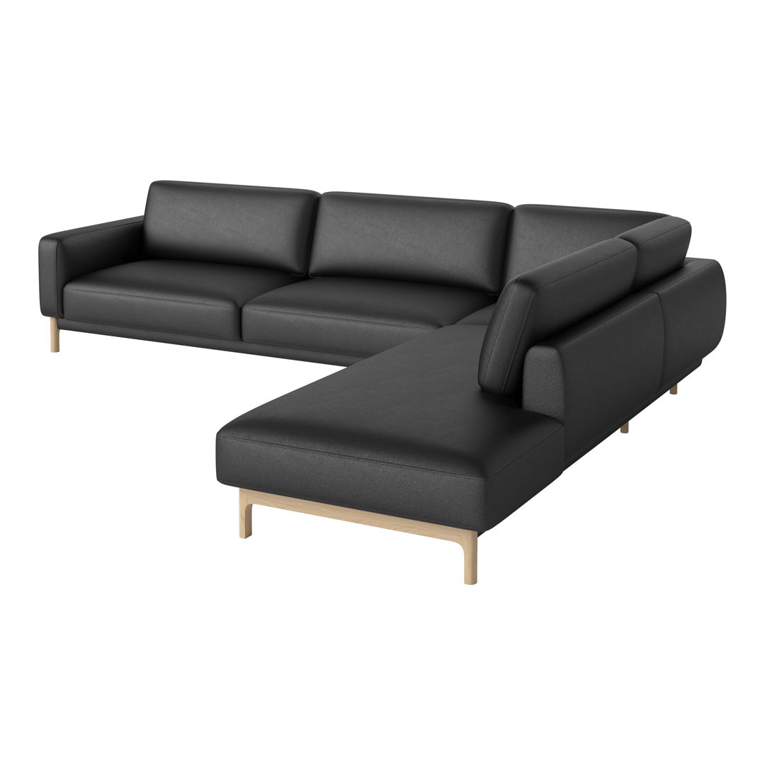Black leather sectional sofa with a sleek design and natural wood legs. Perfect for modern living spaces.