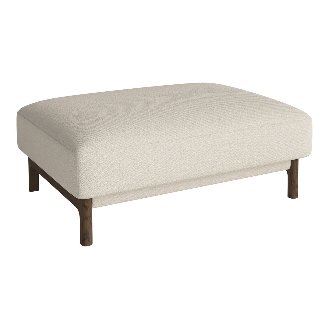 Cream-colored upholstered ottoman with a smooth texture and dark wood legs. Simple, modern, and elegant design.