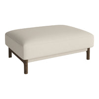 Cream-colored upholstered ottoman with a smooth texture and dark wood legs. Simple, modern, and elegant design.