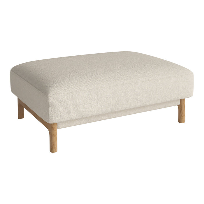 Cream upholstered ottoman with soft texture and natural wooden legs. Modern and minimalist design.
