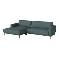 Teal sectional sofa with a smooth, solid upholstery and sleek wooden legs, perfect for modern living spaces.