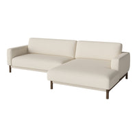 Cream-colored sectional sofa with a modern design and clean lines, featuring smooth fabric and wooden legs.