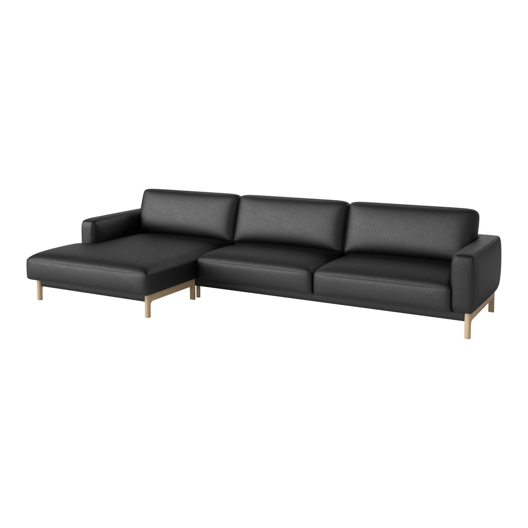 Black leather sectional sofa with sleek design and minimalist gold legs, perfect for modern interiors.
