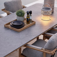 Stylish gray dining table with a stone-like finish; complemented by wooden accents and soft gray cushions.