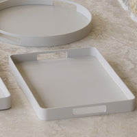 Light gray rectangular serving tray with smooth, minimalist design and cut-out handles, perfect for modern decor.