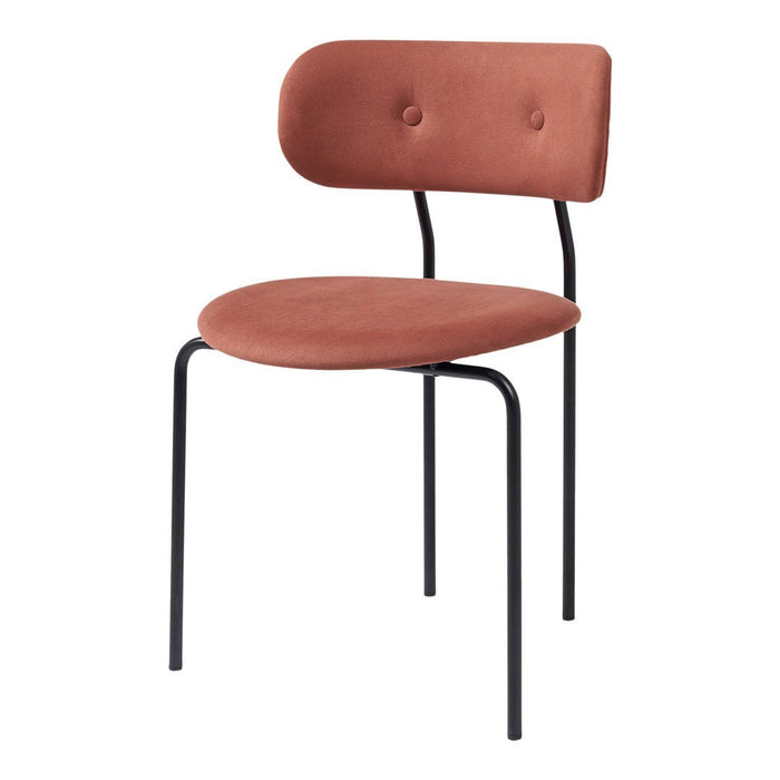 Rust-colored fabric chair with a smooth, rounded seat and back, featuring a sleek black metal frame.
