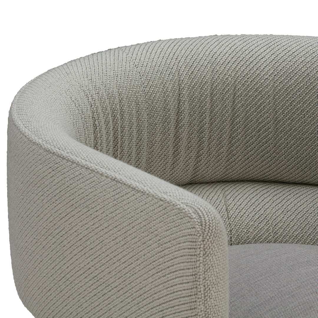 Gray textured fabric with a ribbed pattern on a modern, curved sofa armrest. Elegant and stylish design for any decor.