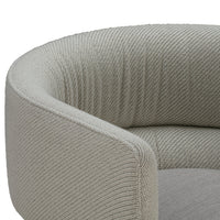 Gray textured fabric with a ribbed pattern on a modern, curved sofa armrest. Elegant and stylish design for any decor.
