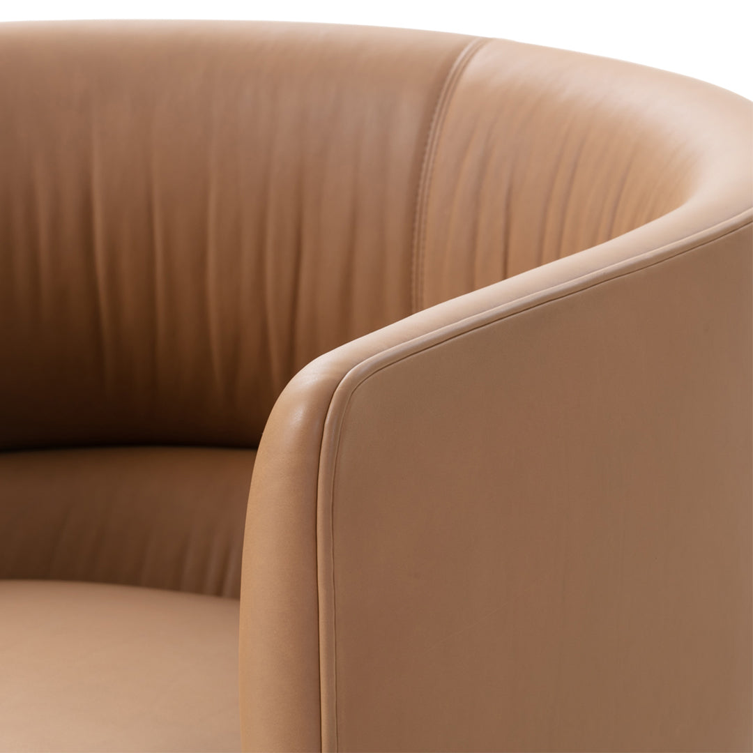 Tan leather armchair featuring smooth, ribbed upholstery and rounded armrests for a modern, elegant look.