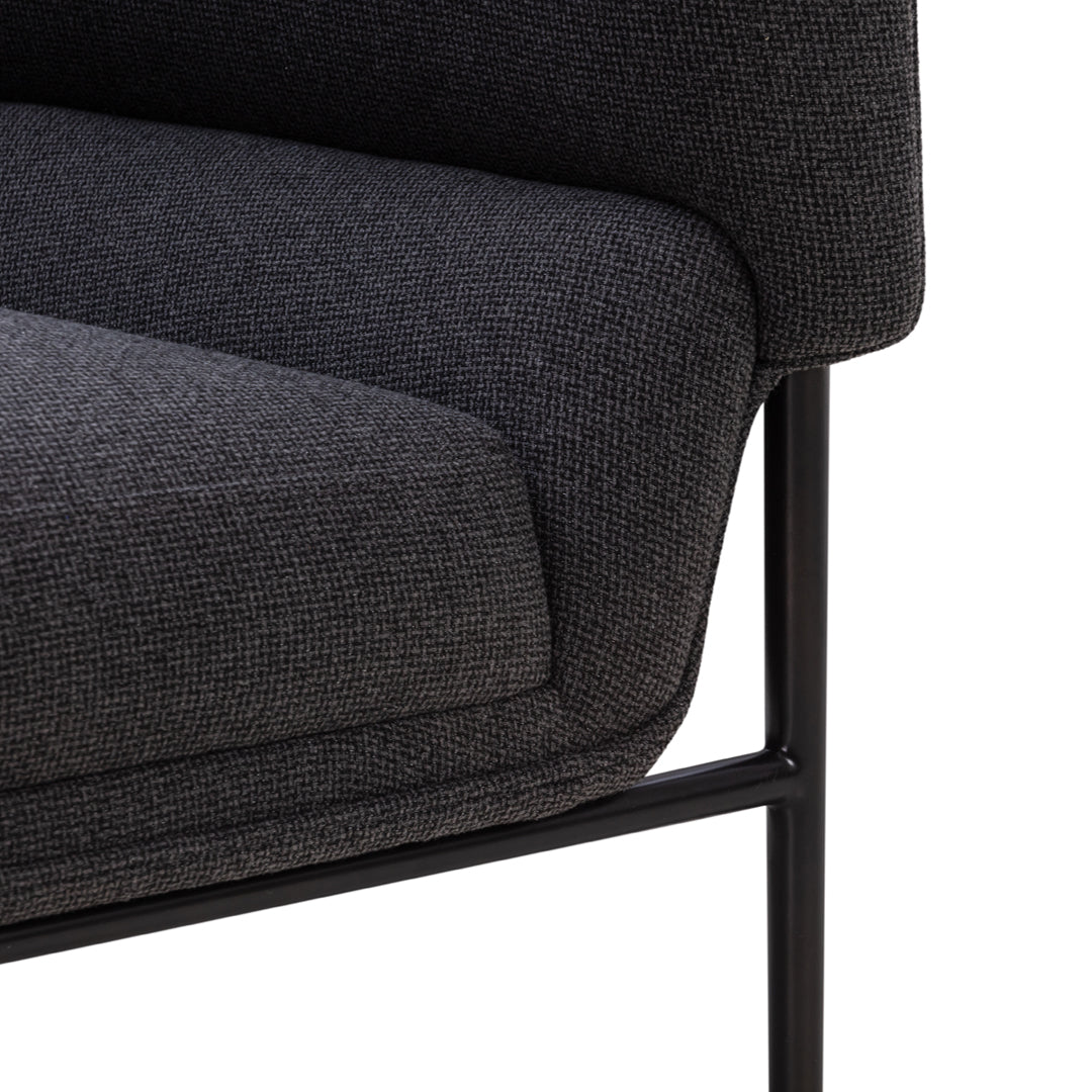 Dark gray upholstery with a subtle textured pattern, complemented by a sleek black metal frame.