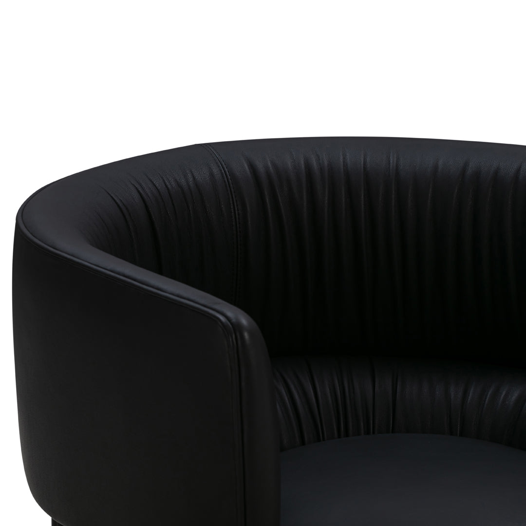 Black faux leather chair with ribbed texture and rounded design. Elegant and modern aesthetic for any space.