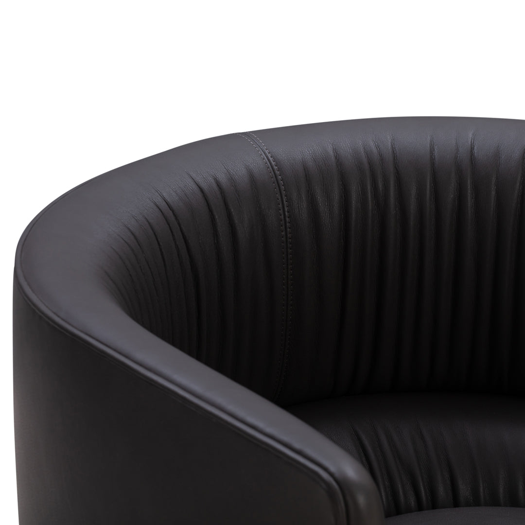 Black leather armchair with ribbed pattern, offering a sleek and modern aesthetic. Perfect for contemporary spaces.