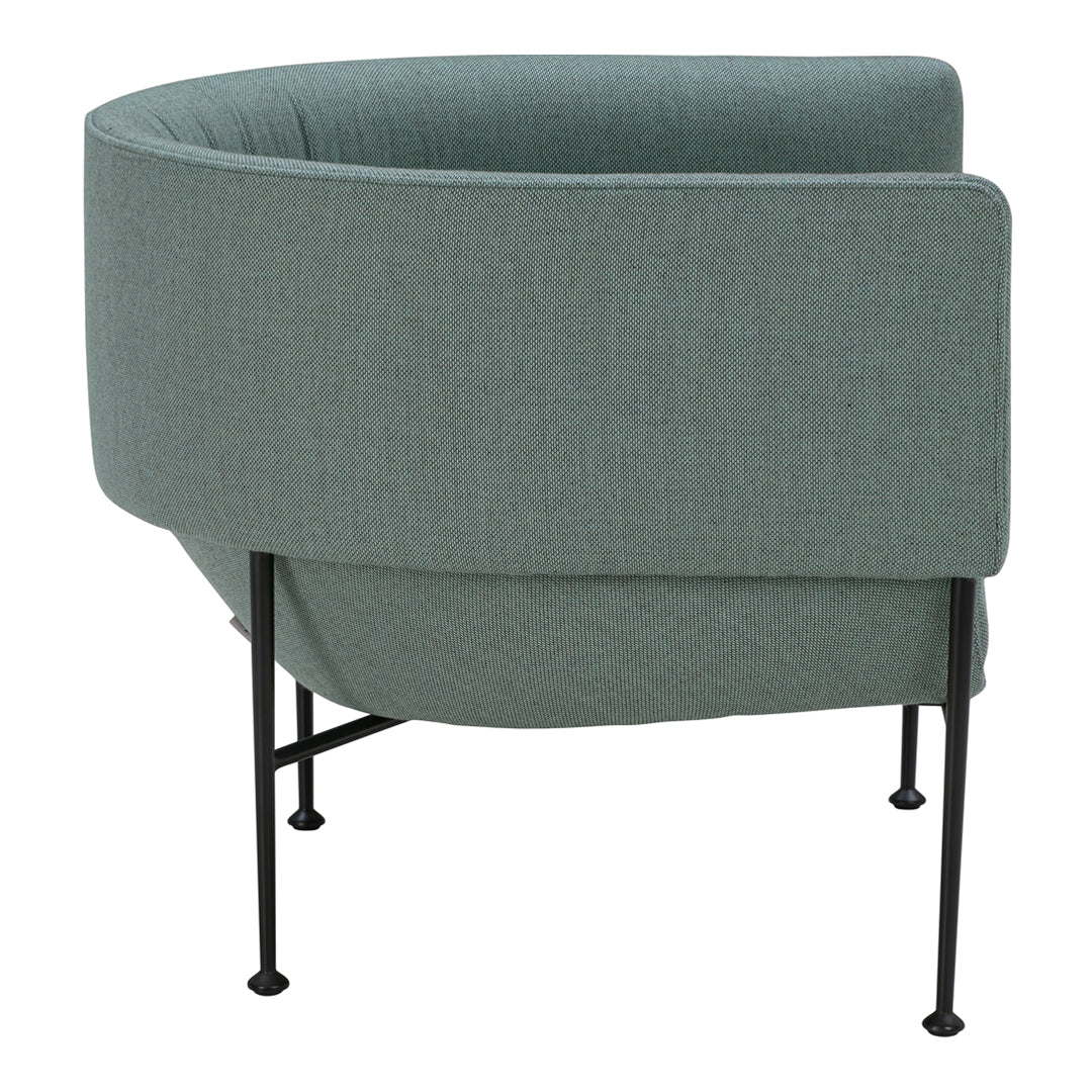 Curved chair in soft teal fabric with textured pattern, supported by sleek black metal legs.