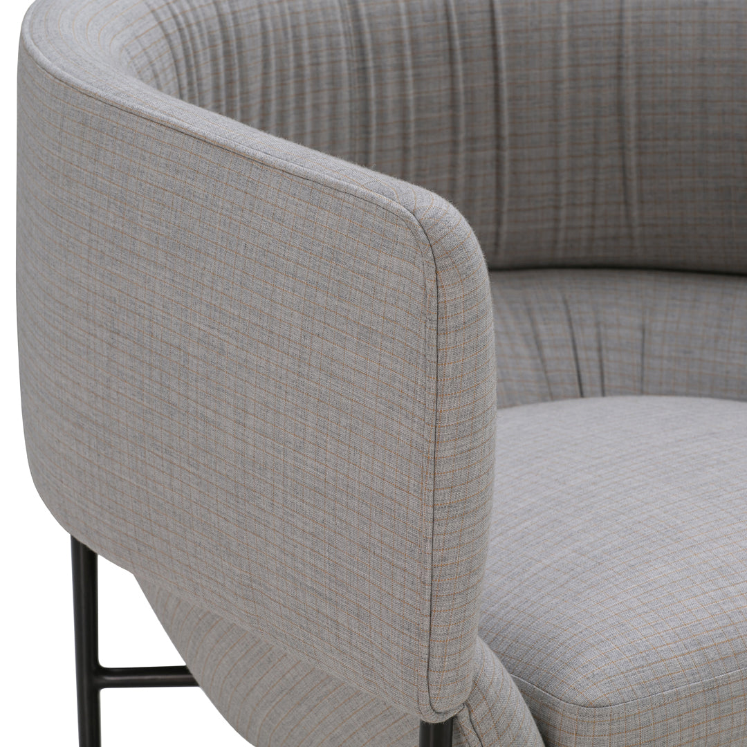 Light gray fabric upholstery with subtle checked pattern on modern circular chair armrest. Elegant and contemporary design.