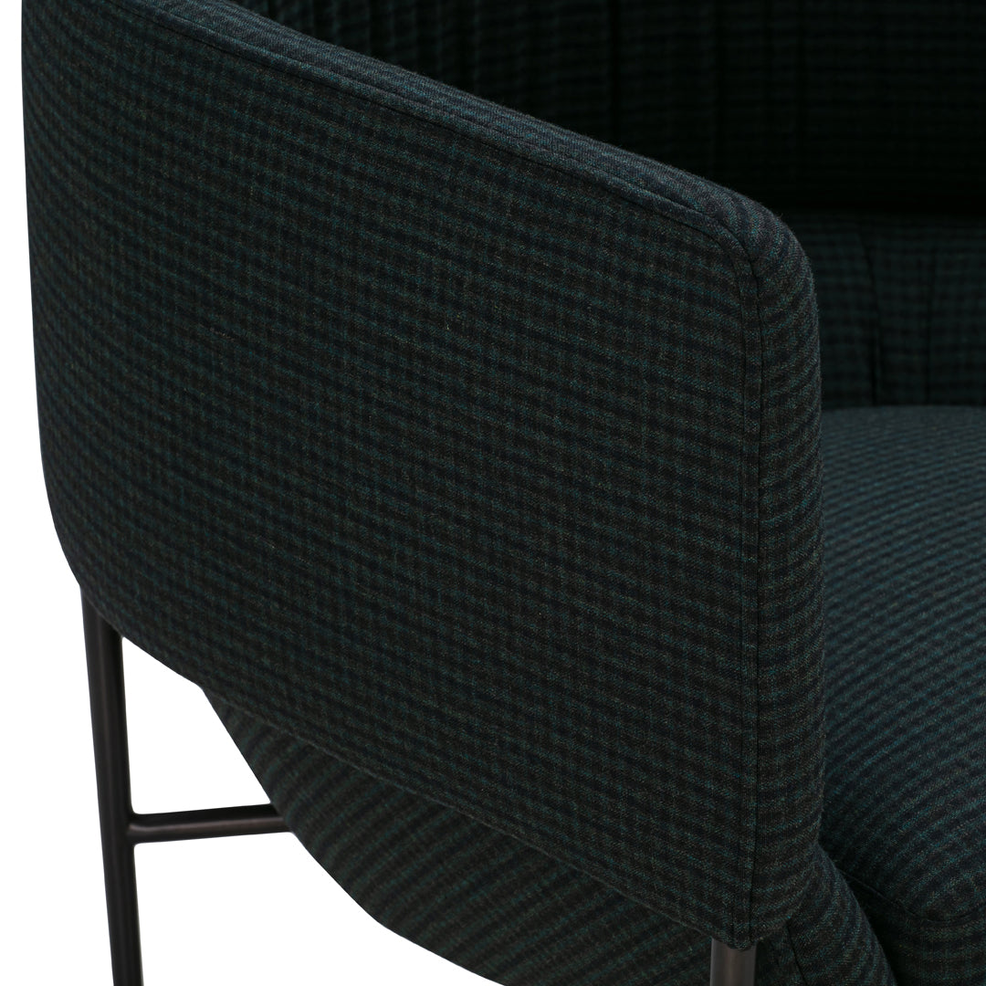 Dark green and black woven fabric featuring a subtle checkered pattern on a modern chair armrest.