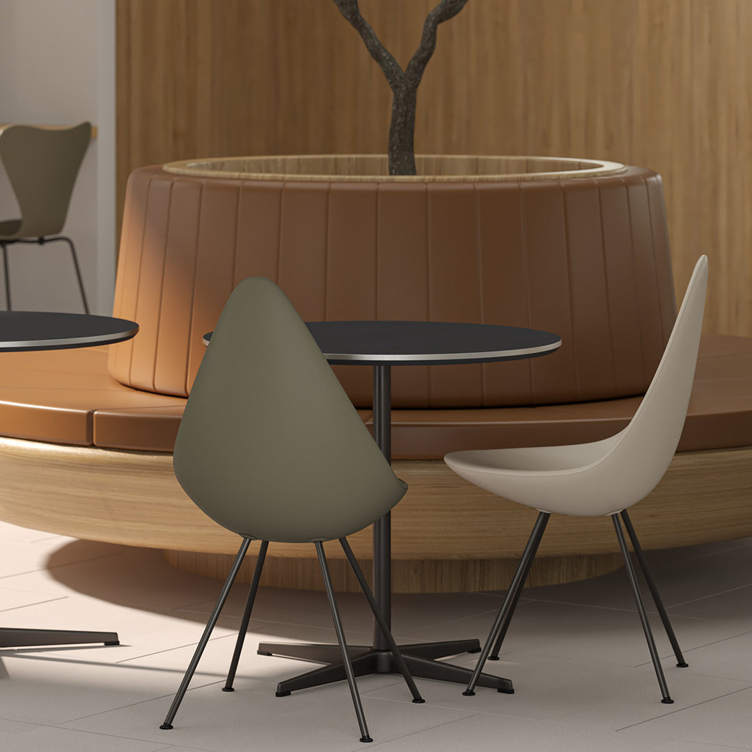 Elegant olive green and soft beige chairs around a sleek black table, set against a warm wooden backdrop.