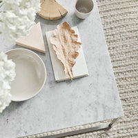 Neutral tones with soft beige and white accents, featuring a textured leaf, minimalist shapes, and natural materials.