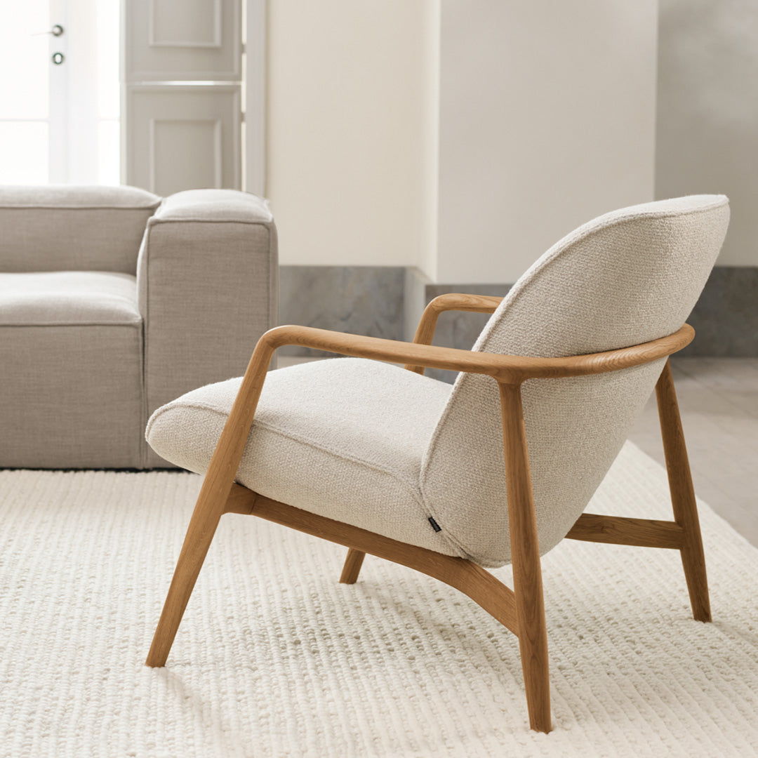 Light beige armchair with a natural wood frame, featuring a smooth, minimalist design and textured upholstery.
