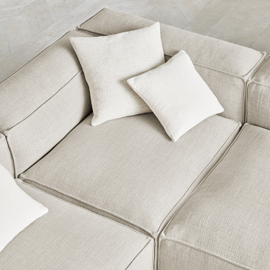 Neutral beige sofa with textured upholstery and coordinating cream throw pillows, creating a cozy, elegant look.