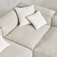 Neutral beige sofa with textured upholstery and coordinating cream throw pillows, creating a cozy, elegant look.
