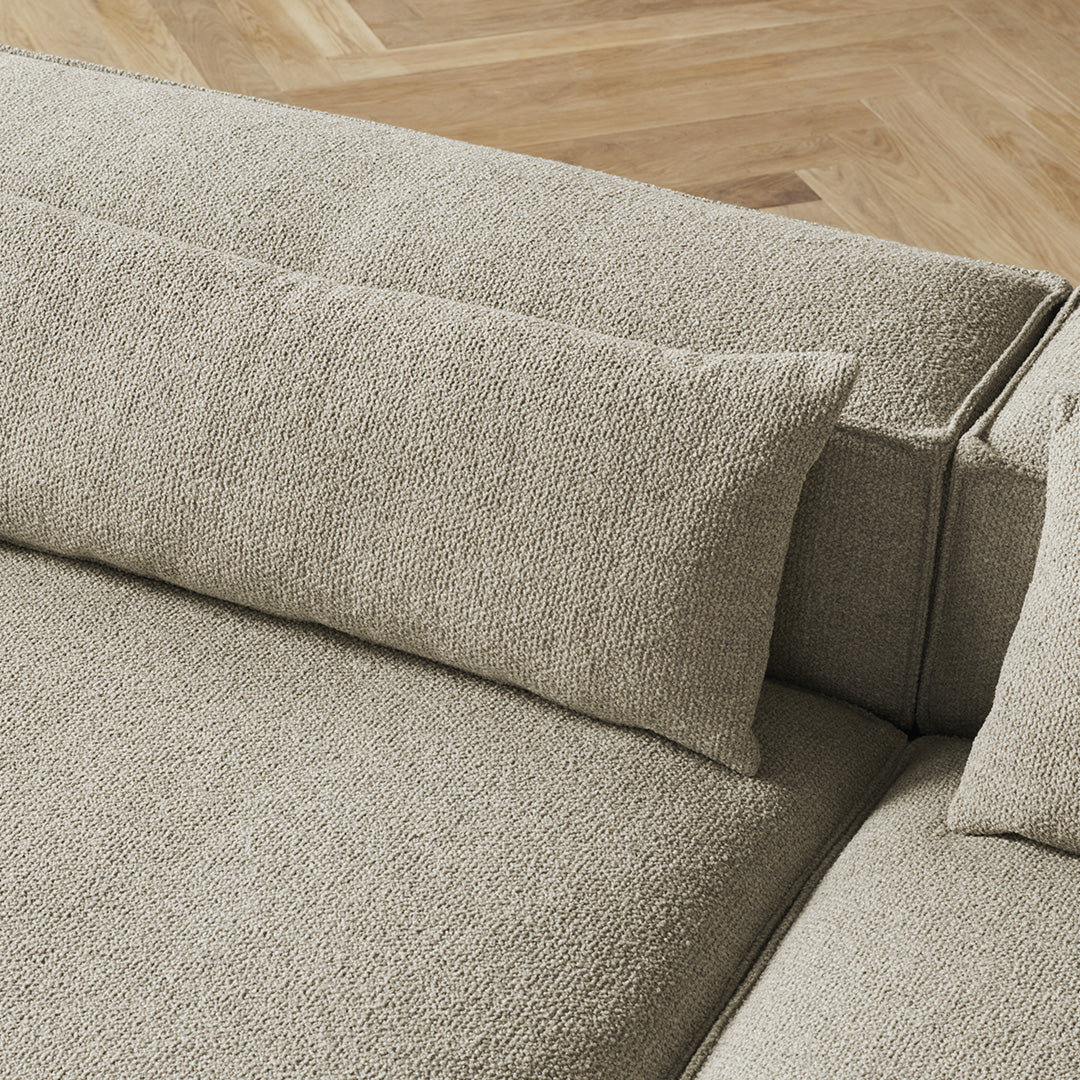 Light beige textured upholstery with a smooth, minimalist design and subtle patterned cushions on a modern sofa.