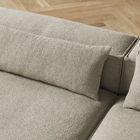 Light beige textured upholstery with a smooth, minimalist design and subtle patterned cushions on a modern sofa.