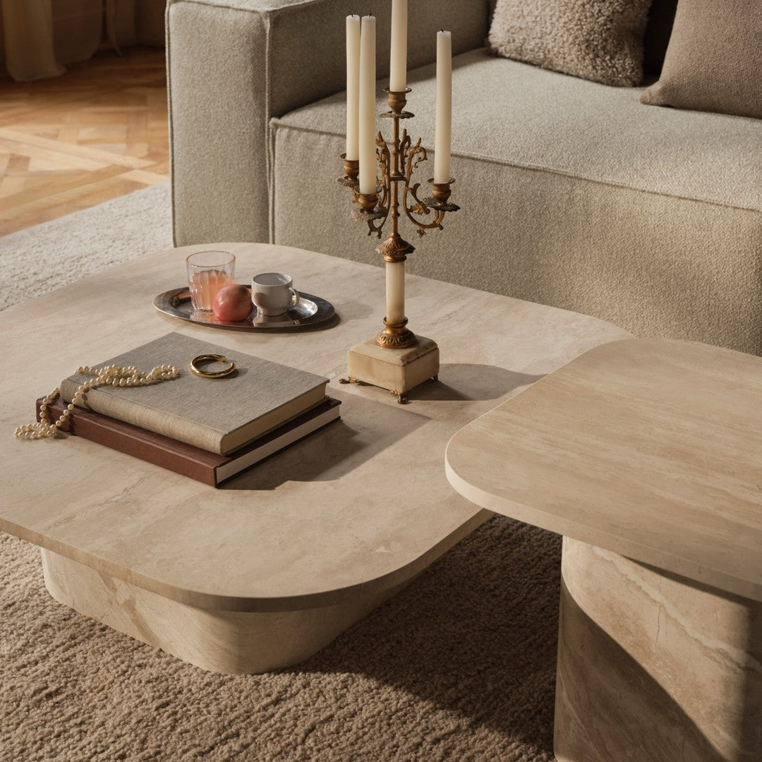 Light beige coffee table with smooth, rounded edges on a soft, textured rug. Elegant, neutral living room decor.