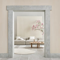 "Soft gray textured wall frame with pastel pink floral decor and neutral beige living room furnishings."