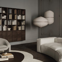 Textured beige sofa and round rug against a dark wood floor; modern light fixtures with cream and brown stripes.