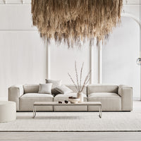 Neutral beige sofa with streamlined design, complemented by subtle textured pillows and a cozy light rug.